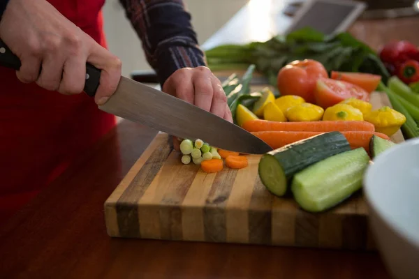 Mujer cortando verduras en la cocina — Foto de Stock