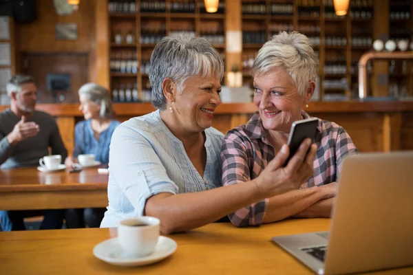 Senior friends using phone — Stock Photo, Image