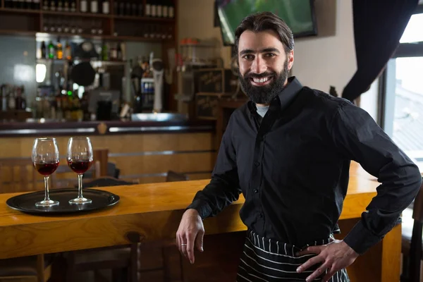 Bar tender leaning at bar counter — Stock Photo, Image