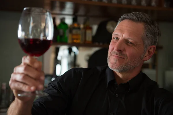 Waiter looking at a glass of wine — Stock Photo, Image