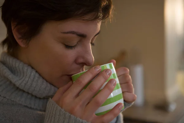 Vrouw drinkt koffie in de keuken — Stockfoto