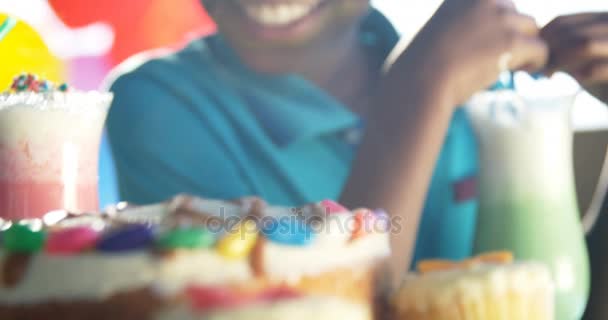 Ragazzo che mangia dolci e beve nel parco giochi — Video Stock