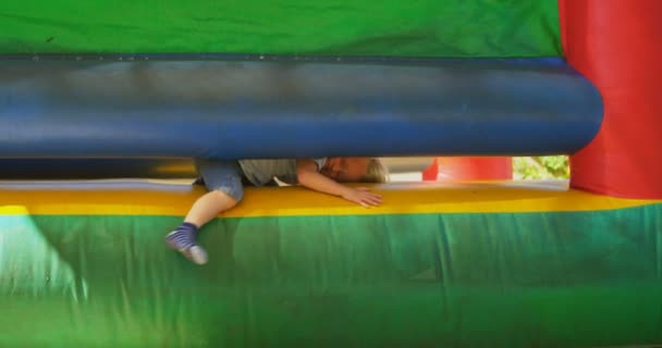 Boy coming out from bouncing castle — Stock Video