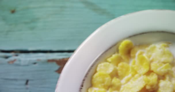 Cereales de desayuno en tazón sobre mesa de madera — Vídeos de Stock
