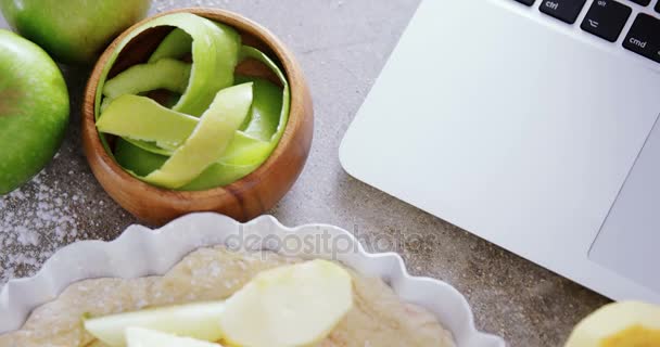 Laptop com torta de maçã e maçã verde descascada — Vídeo de Stock