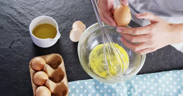 Kobieta rozbijania jaj do miski — Wideo stockowe