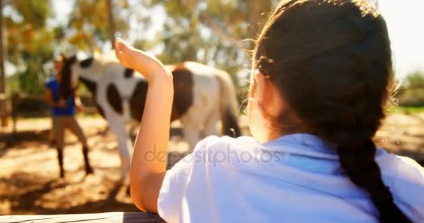 Девушка машет рукой своей матери на ранчо — стоковое видео