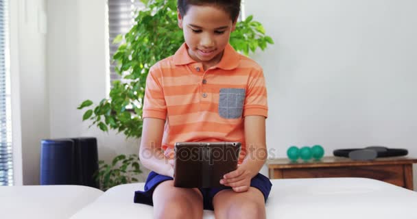 Мальчик с цифровым планшетом на кровати — стоковое видео