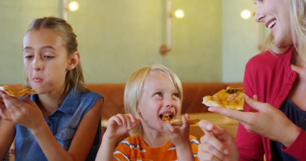 Moeder en kinderen met pizza in restaurant — Stockvideo