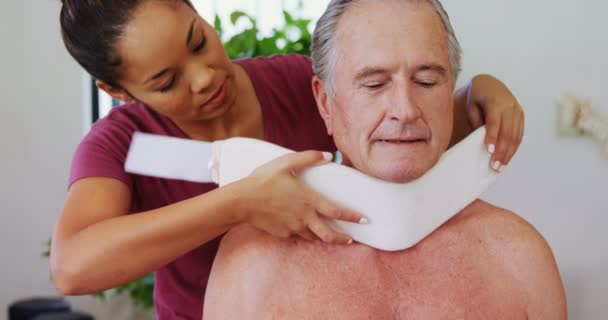 Физиотерапевт настраивает шейный воротник на шее пациента — стоковое видео