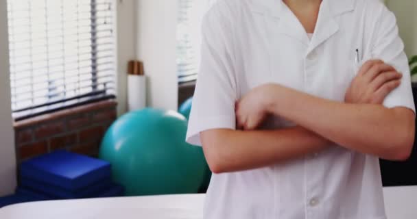 Fyzioterapeut, stál s rukama zkříženýma na klinice — Stock video