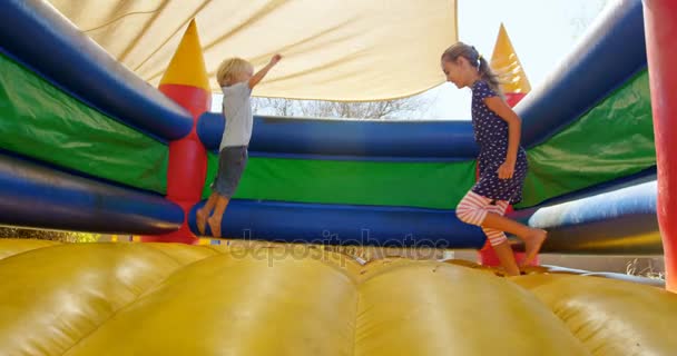 Enfants jouant sur le château rebondissant — Video