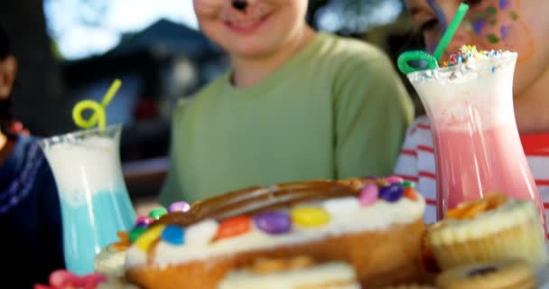 Crianças que têm comida doce e bebidas no parque infantil — Vídeo de Stock