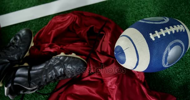 Cleats, jersey y pelota de rugby en césped artificial — Vídeo de stock