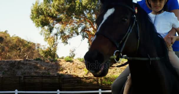 Madre que ayuda a hija durante montar a caballo — Vídeos de Stock