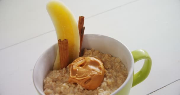 Cup of oats with peanut butter — Stock Video