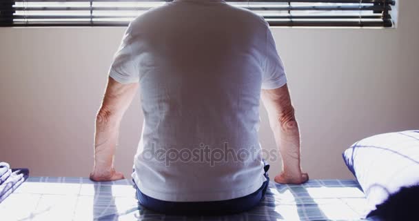 Pohled zezadu na starší muž, sedící na posteli vyšetření — Stock video