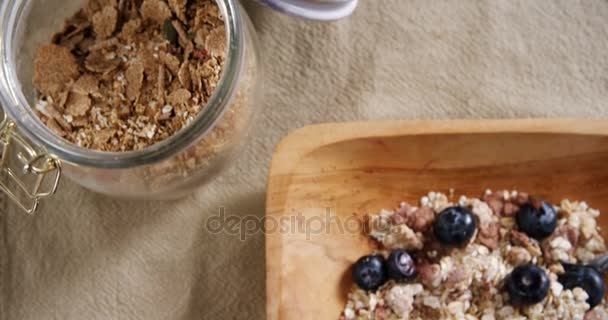 Kruik en kom ontbijtgranen met lepel — Stockvideo
