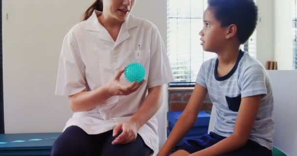 Physiotherapist talking to boy — Stock Video