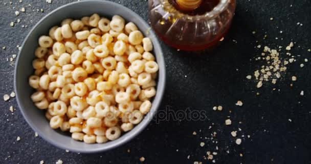 Cereal rings with honey and honey dipper — Stock Video