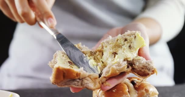 Mujer aplicando mantequilla sobre pan multigrano — Vídeos de Stock