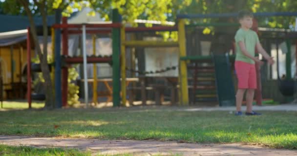 Kinder fahren mit dem Fahrrad auf dem Spielplatz — Stockvideo