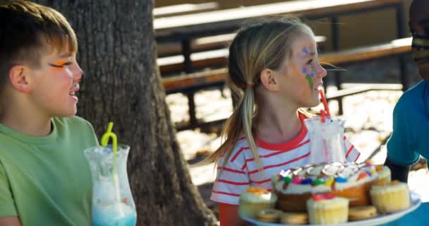 Τα παιδιά, έχοντας τα γλυκά τρόφιμα και ποτά στην παιδική χαρά — Αρχείο Βίντεο