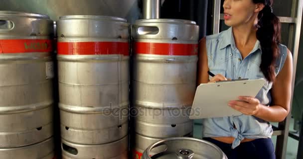 Cervecera femenina manteniendo registro en portapapeles — Vídeos de Stock