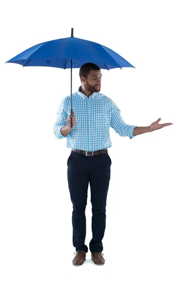 Male executive standing under umbrella — Stock Photo, Image
