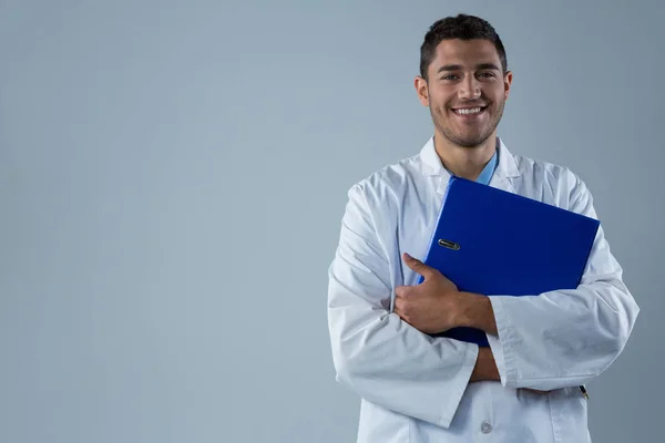 Uśmiechający się lekarz stojący z pliku — Zdjęcie stockowe