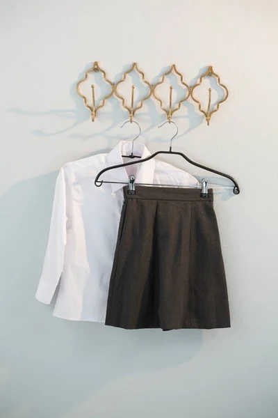 Formal shirt and skirt hanging on hook — Stock Photo, Image