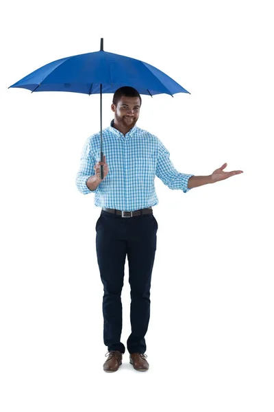 Male executive standing under umbrella — Stock Photo, Image