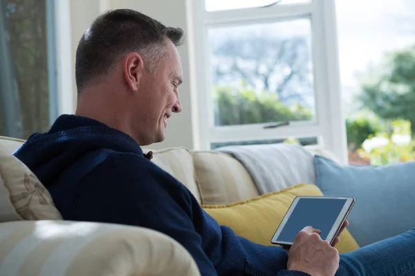 Homem usando tablet digital no sofá — Fotografia de Stock