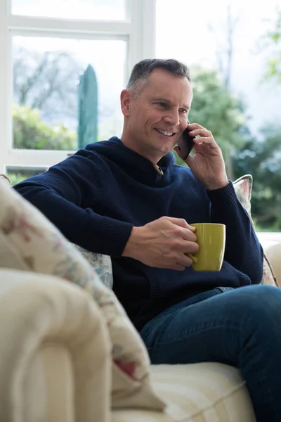 Hombre hablando por teléfono mientras toma café — Foto de Stock