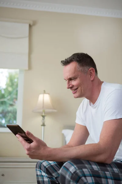 Man using digital tablet on bed — Stock Photo, Image