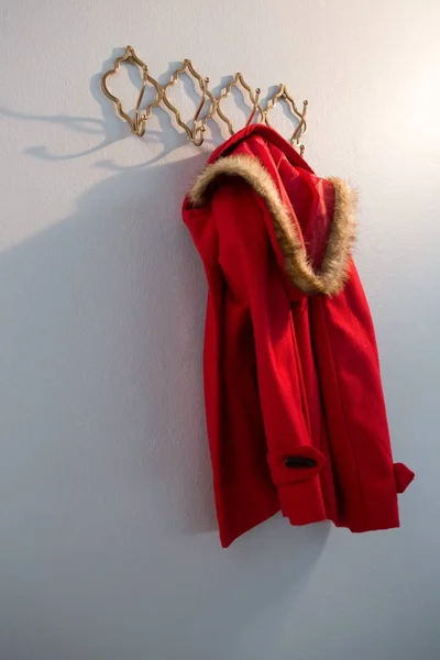 Red hoodie hanging on hook — Stock Photo, Image