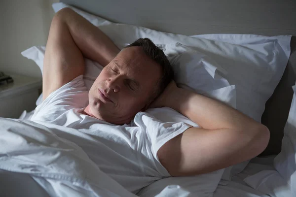 Hombre durmiendo en la cama en el dormitorio —  Fotos de Stock