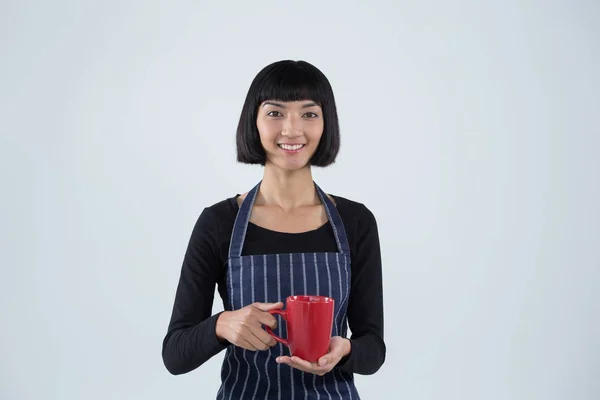 Camarera sonriente sosteniendo taza de café —  Fotos de Stock