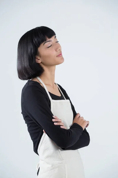 Pensive waitress standing with arms crossed — Stock Photo, Image