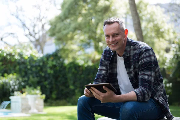 Homme utilisant une tablette numérique dans le jardin — Photo