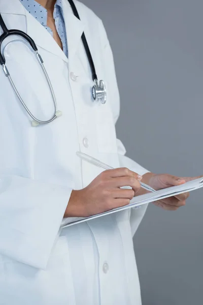 Doctor writing on clipboard — Stock Photo, Image