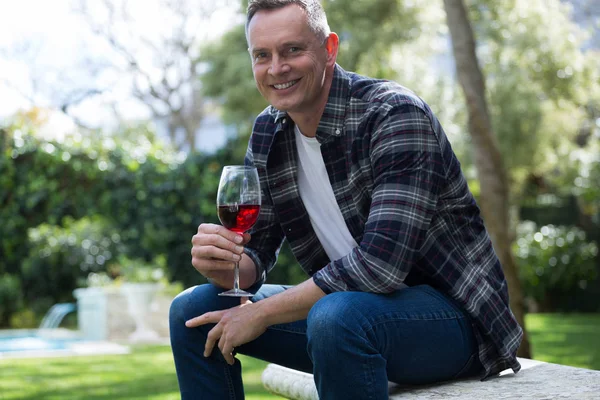 Homme souriant prenant un verre de vin rouge — Photo