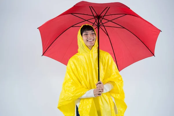 Donna in impermeabile giallo con in mano un ombrello — Foto Stock