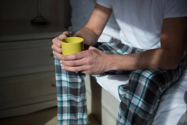 Man having cup of coffee in bedroom — Stock Photo, Image