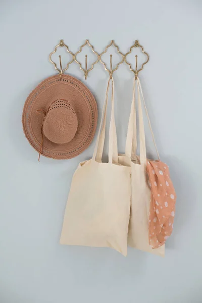 Sombrero, bolsa de supermercado y bufanda colgando de un gancho — Foto de Stock
