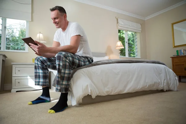 Uomo che utilizza tablet digitale sul letto — Foto Stock