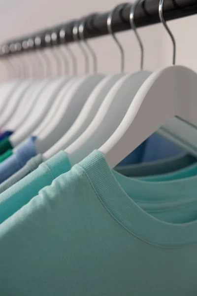 T-shirts coloridas dispostas em uma fileira no rack de pano — Fotografia de Stock