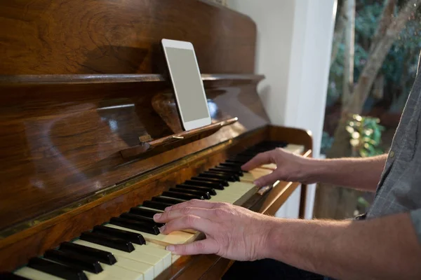 Mężczyzna gra na pianinie w domu — Zdjęcie stockowe