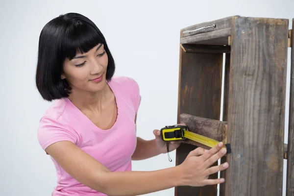 Woman measuring furniture with tape measure — Stock Photo, Image