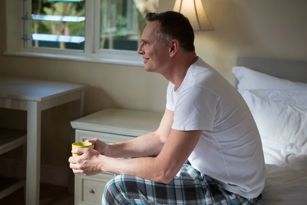 Mann mit Tasse Kaffee im Schlafzimmer — Stockfoto